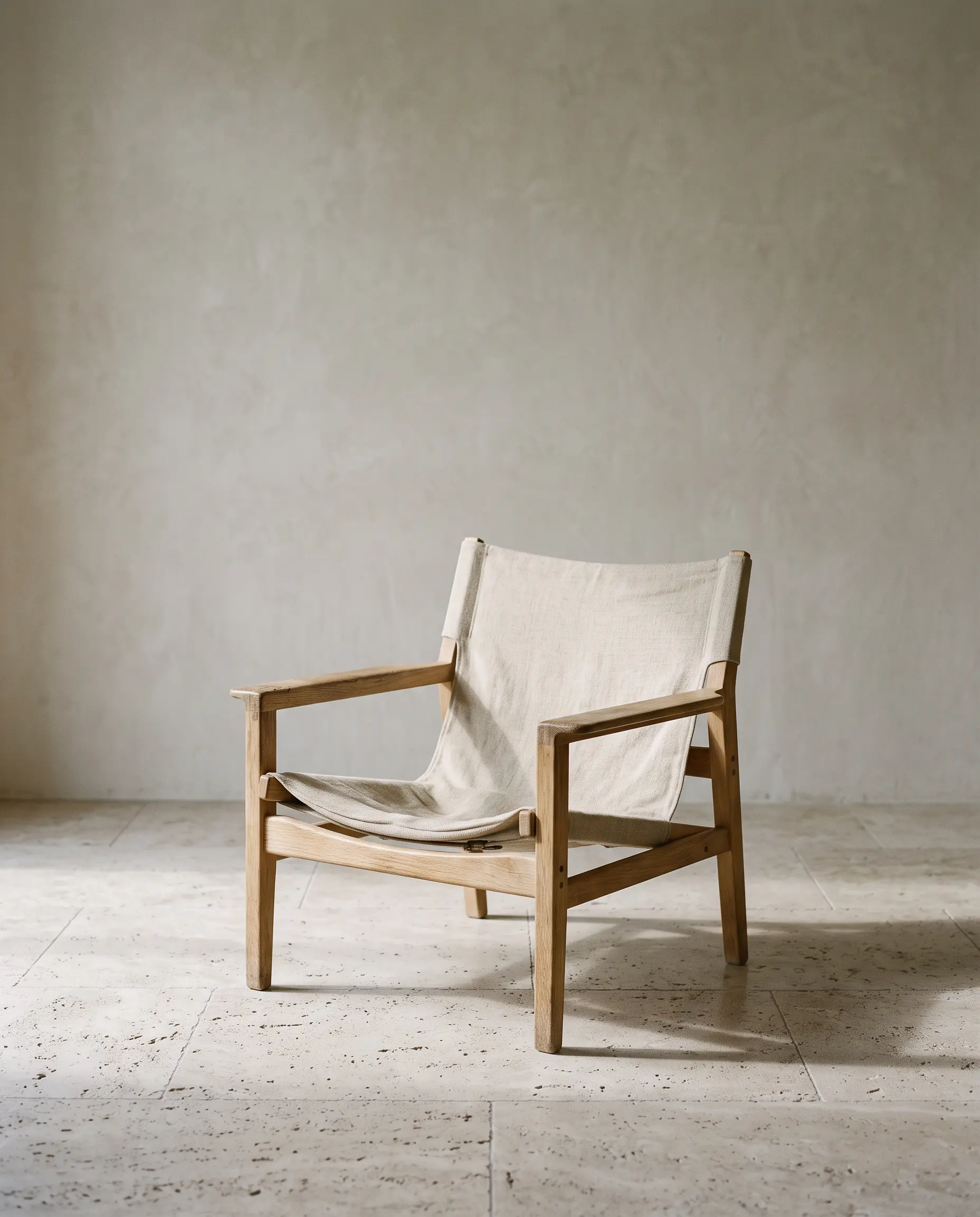 A single upholstered chair against a plastered wall at The Hay Barn.