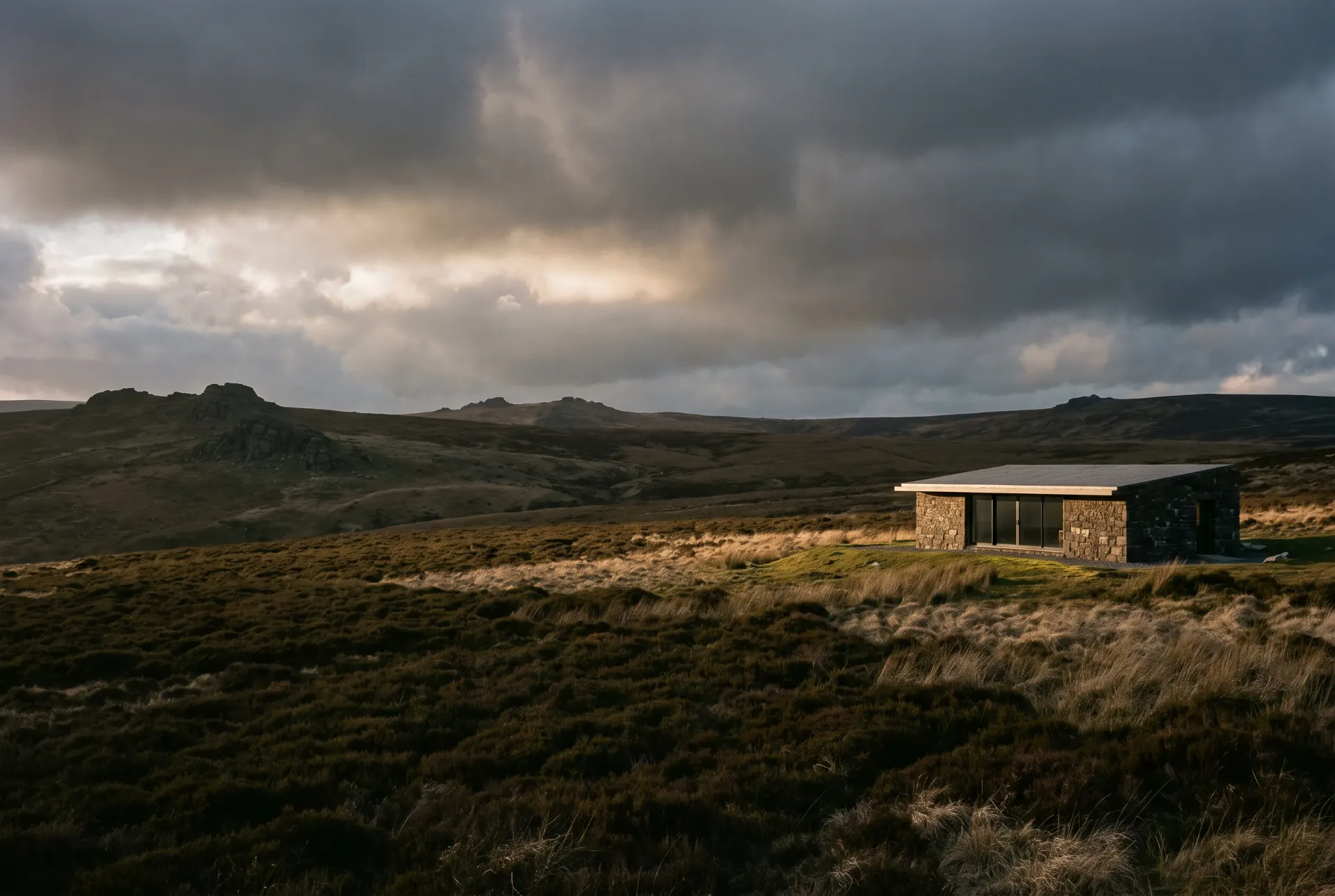 Granite House, Dartmoor: a granite farmhouse with a concrete extension, evening light on the moor.