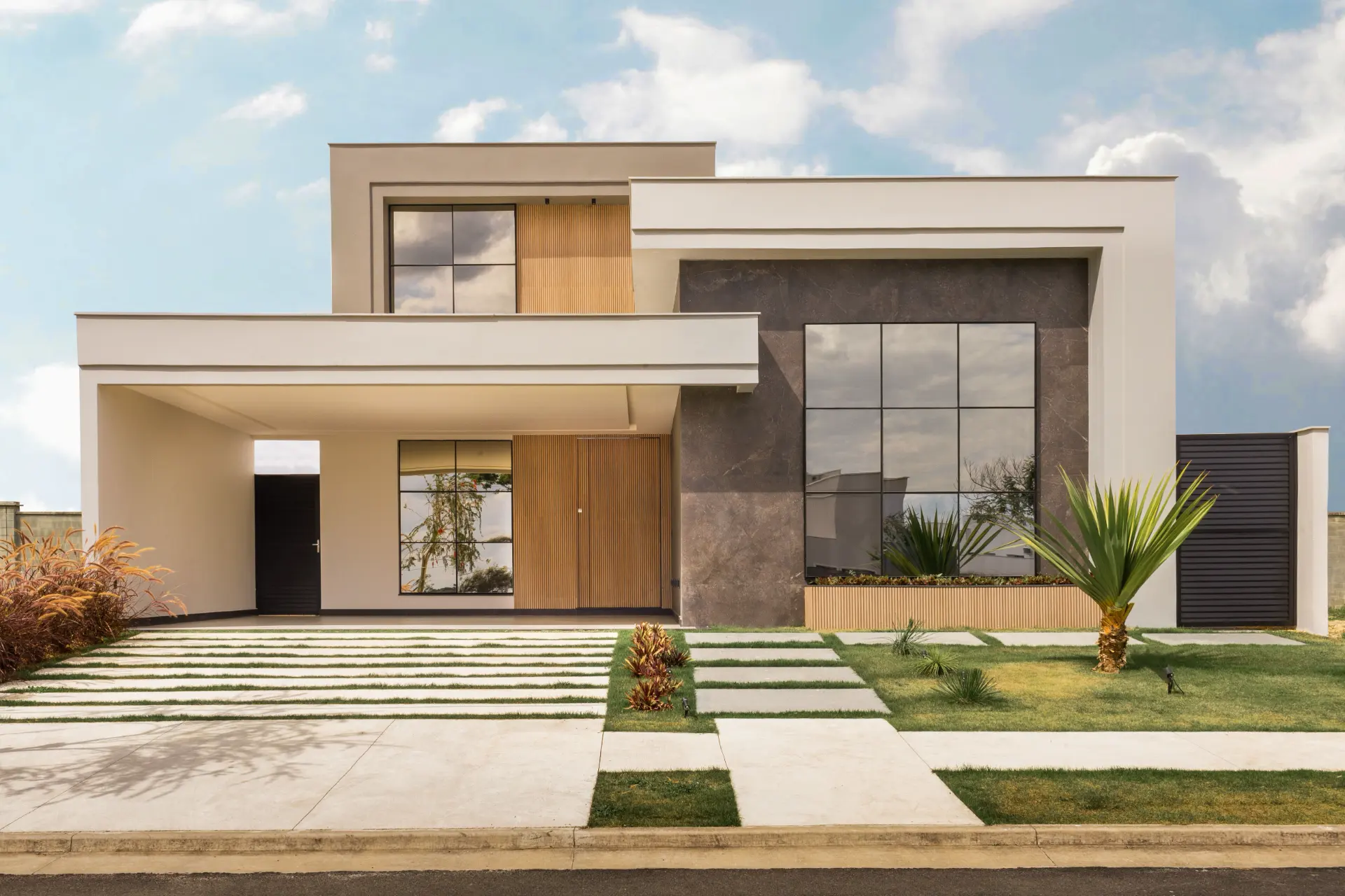 A contemporary two-storey house with white rendered walls, dark stone cladding, timber slats and full-height glazing.
